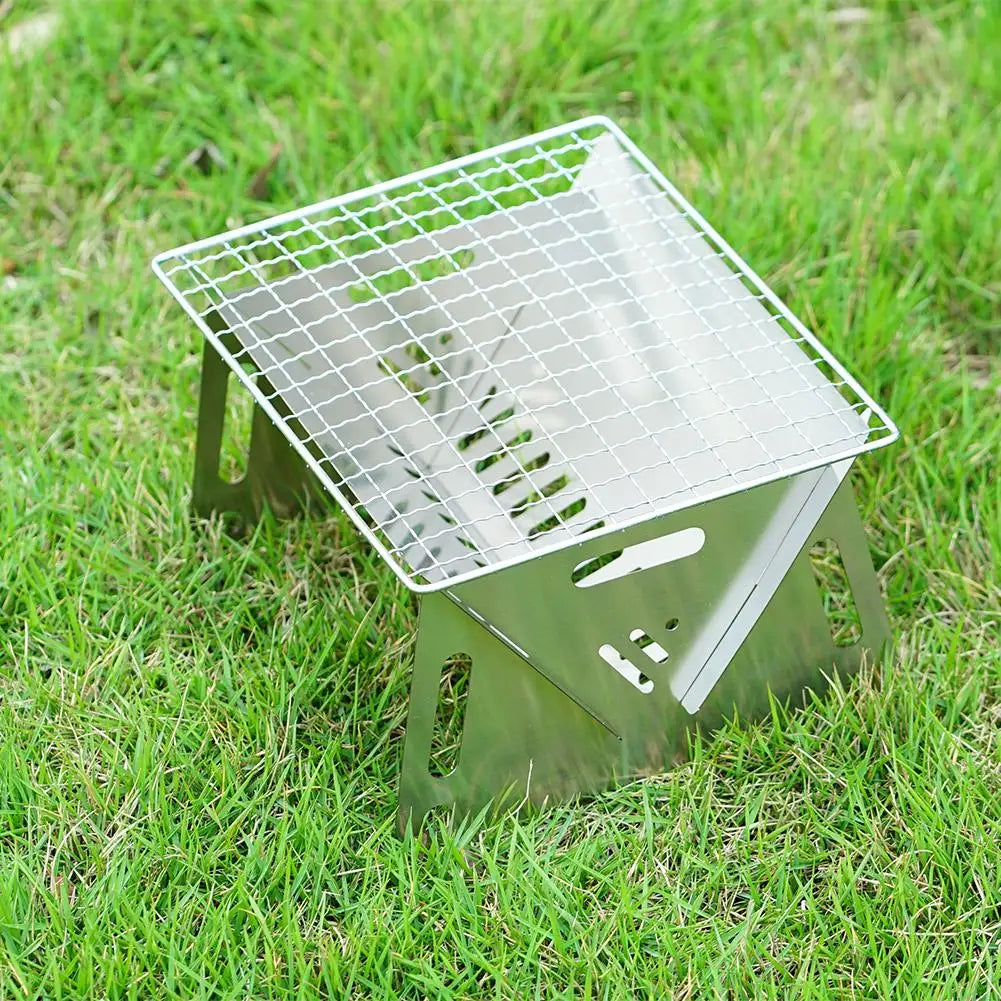 Stainless steel portable folding grill on grass for camping compact lightweight easy to carry