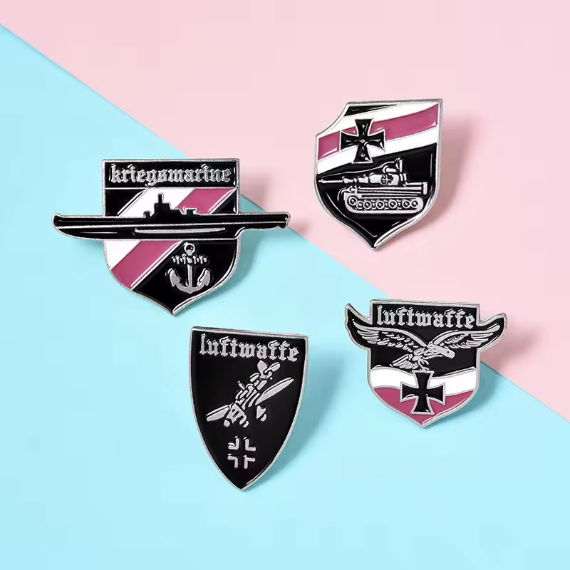 Set of four enamel German Luftwaffe badges with black white and pink shield designs and Luftwaffe text