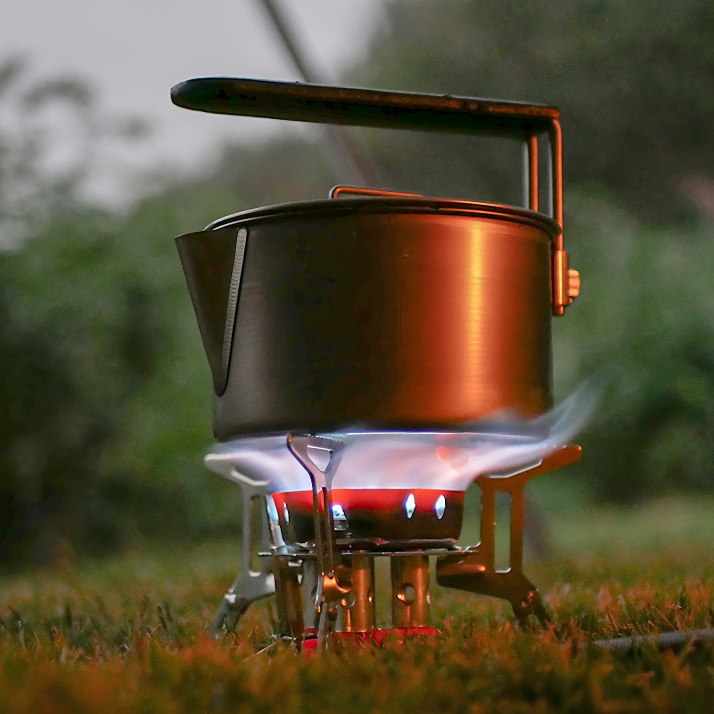 Military Outdoors high-power camping stove with blue flame under metal pot on compact foldable tripod for outdoor cooking