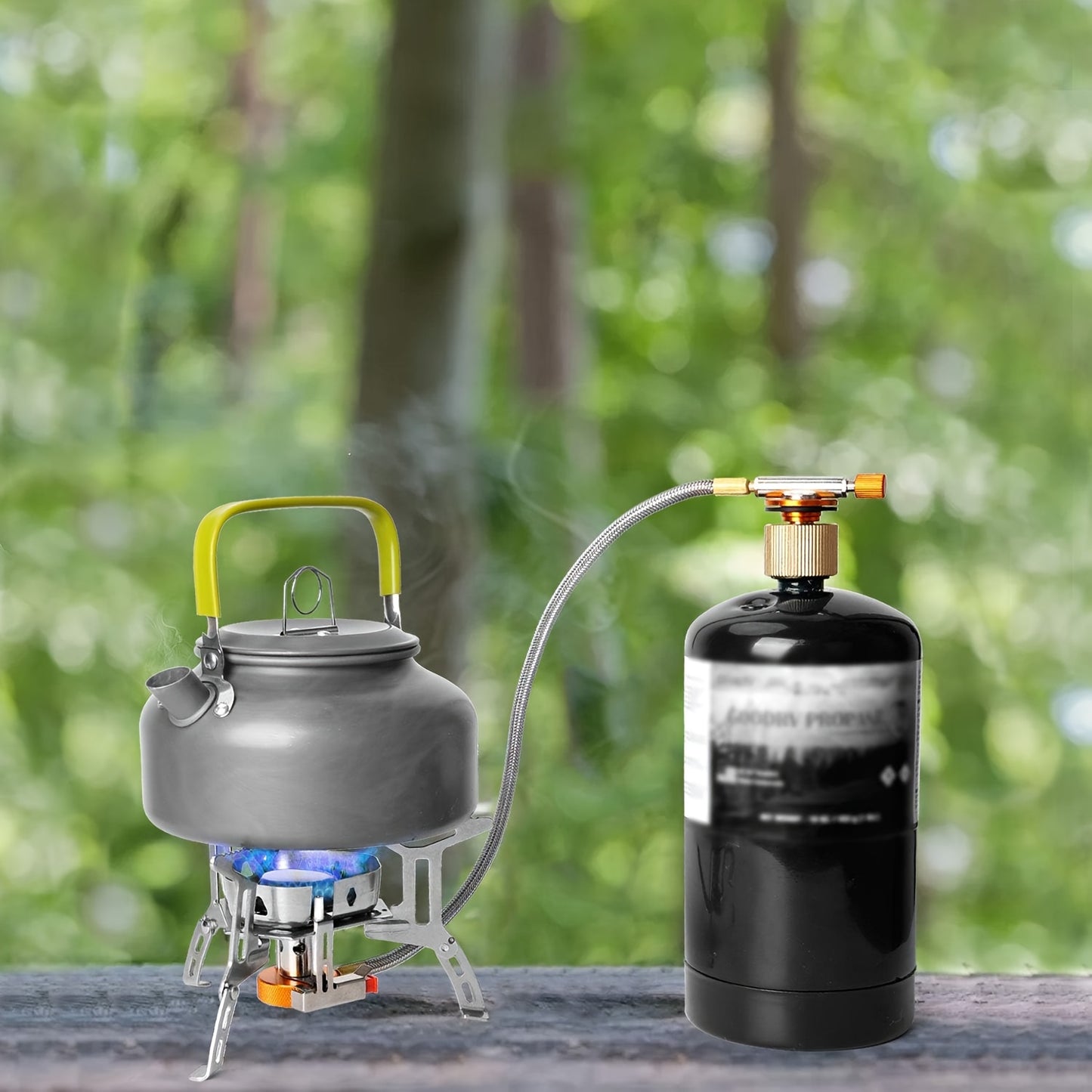 Compact high-power camping stove with kettle on folding tripod burner and external gas canister on campsite