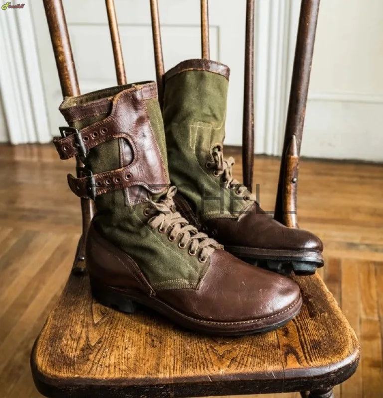 Medieval archery boots in brown leather and green fabric with buckles and laces on wooden chair