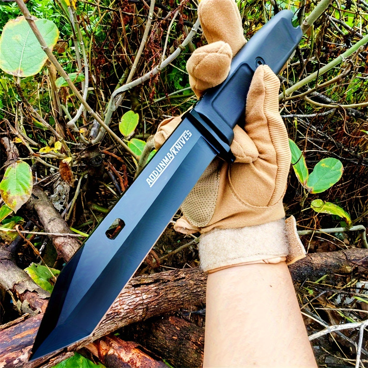 Military Outdoors wilderness survival multi-purpose knife black tanto blade in gloved hand outdoors