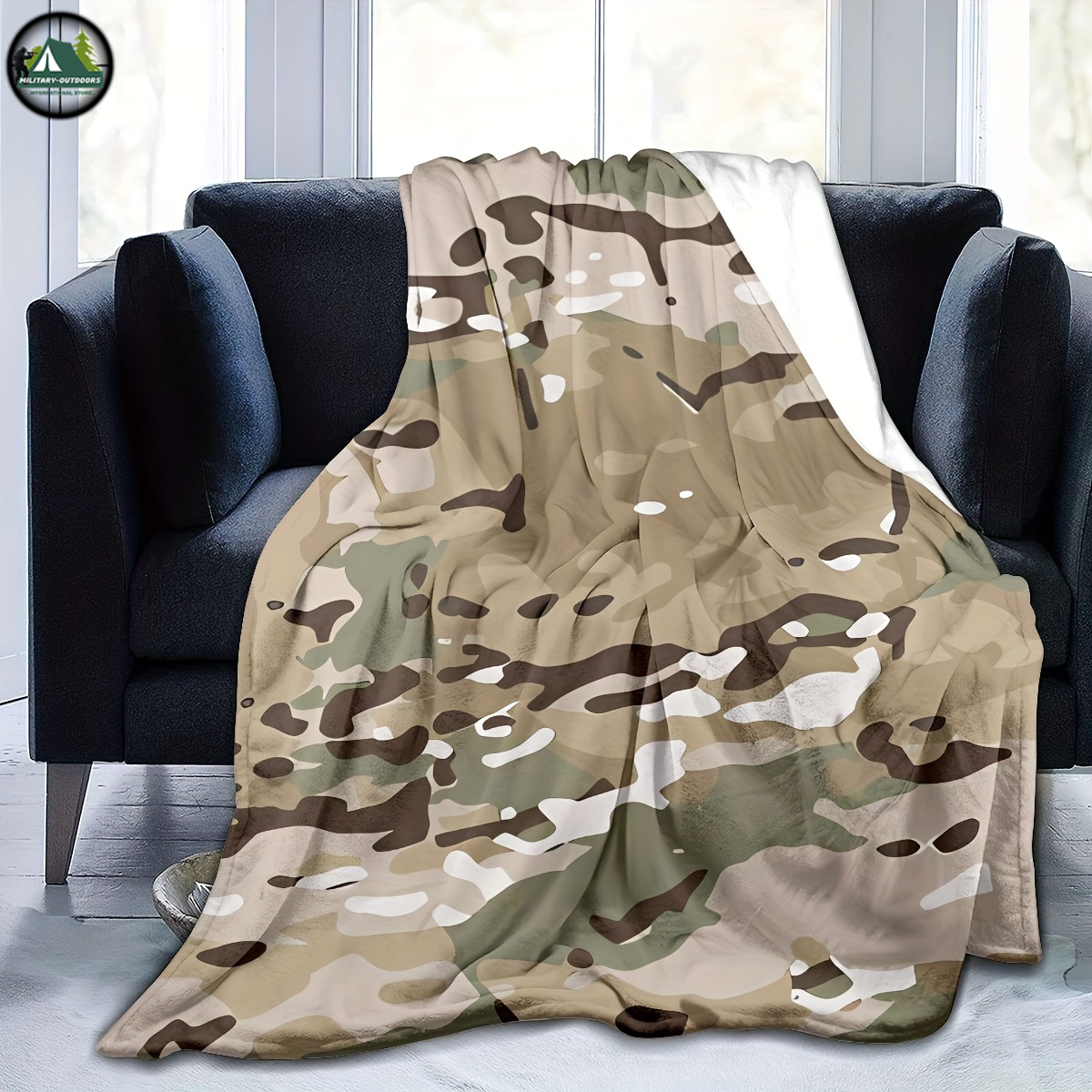 Camouflage flannel blanket draped over black sofa, featuring soft military style pattern from Military-Outdoors.com