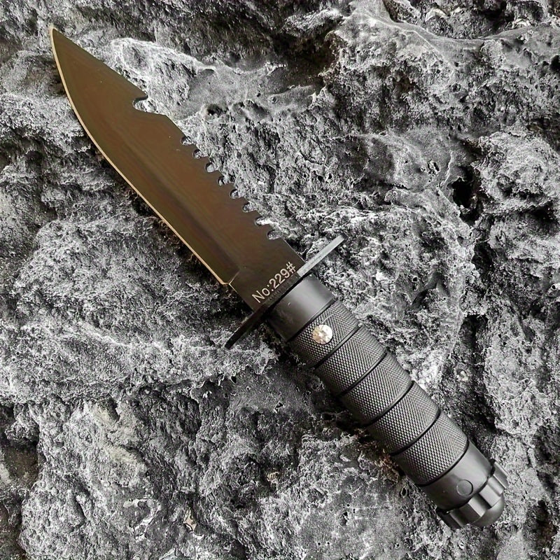Military-Outdoors.com hunting and camping knife with serrated edge and textured black handle on rocky surface
