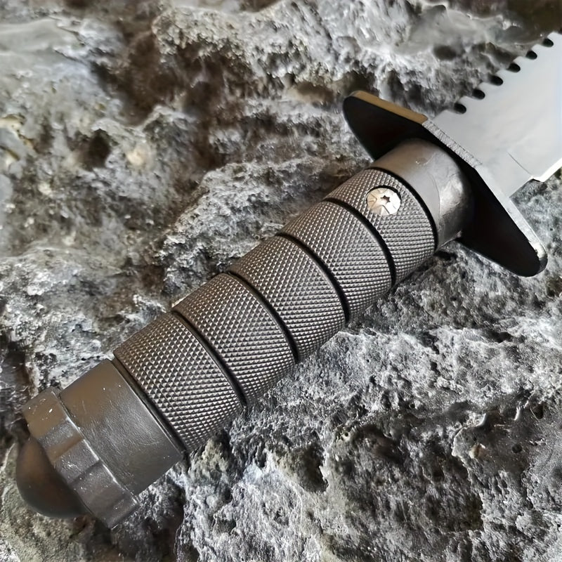 Close-up of a rugged hunting and camping knife with textured grip handle on rocky surface
