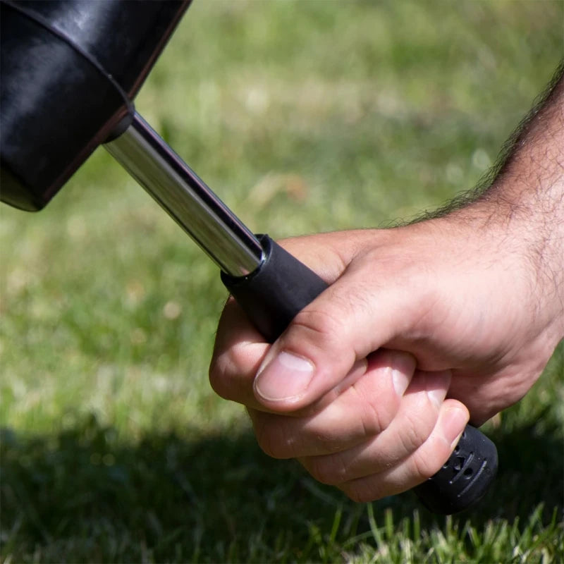 Close-up of a hand gripping a rubber mallet hammer for outdoor use and gardening tasks