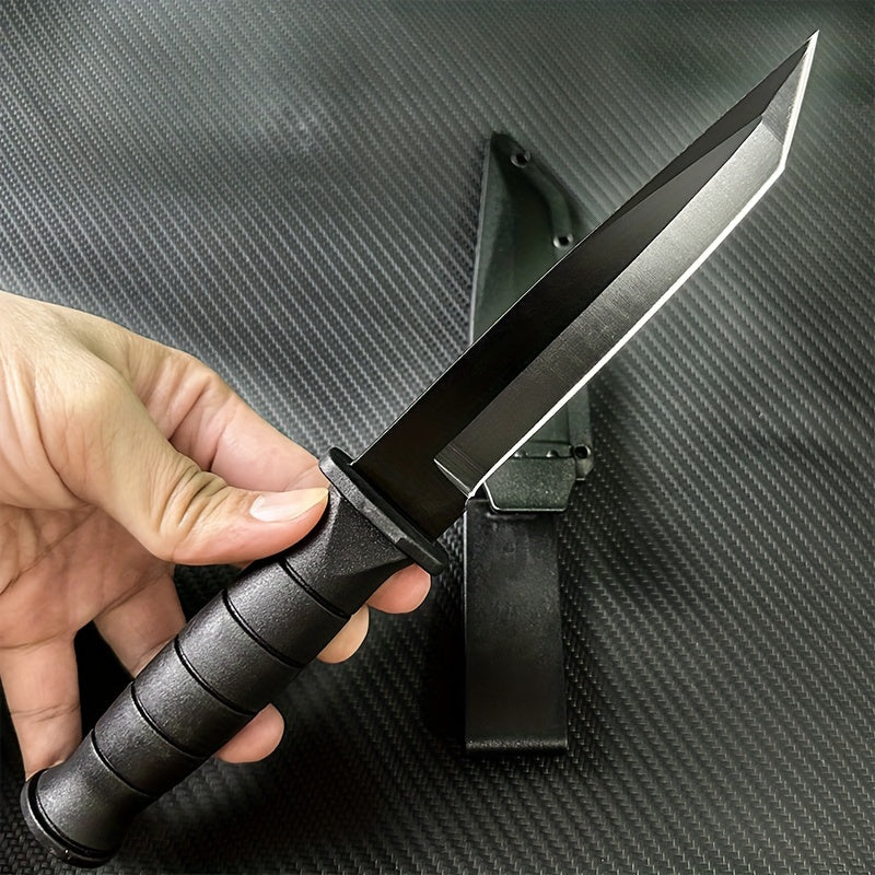Hand holding stainless steel army knife with black handle and sharp blade above black sheath