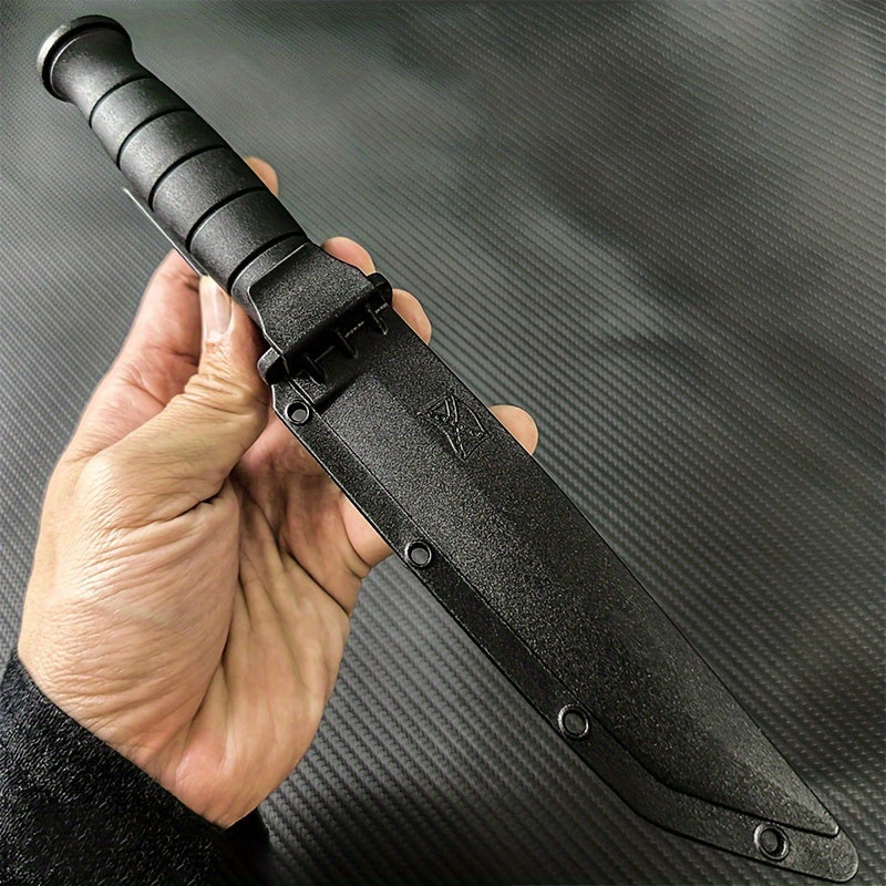 Hand holding black stainless steel army knife with textured grip and protective sheath
