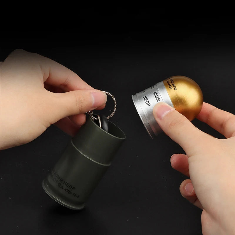 Dummy Grenade Model replica keychain showing green cylindrical body and gold silver spherical top held in hands