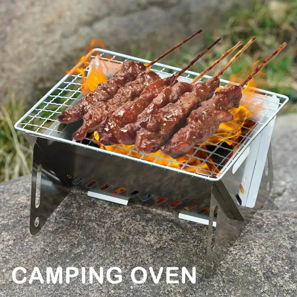 portable folding grill with skewers of meat grilling over flames on a campsite rock