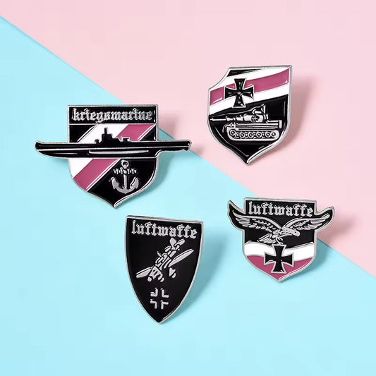 Set of four enamel German Luftwaffe badges with black white and pink shield designs and Luftwaffe text
