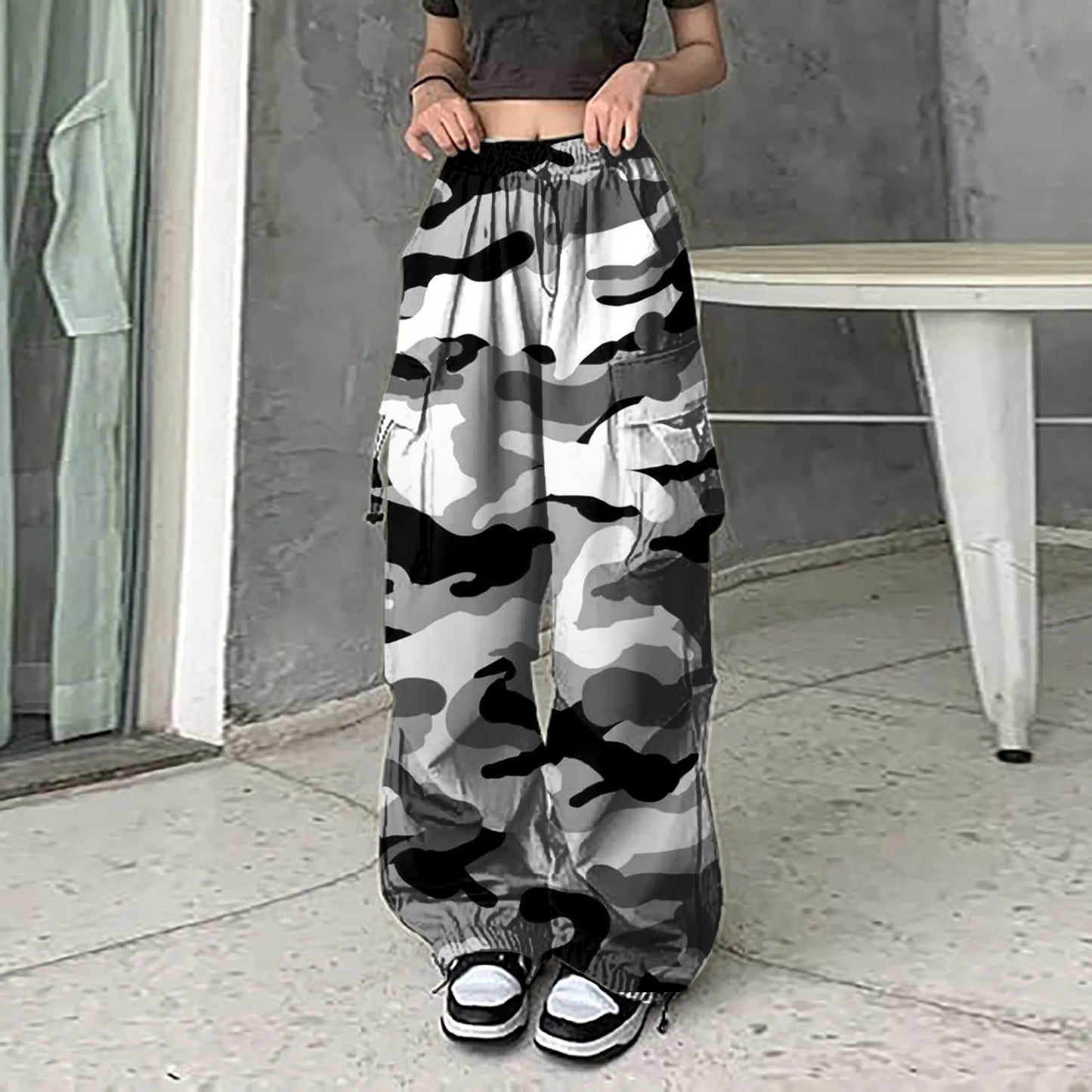 Women wearing vintage camouflage cargo pants with black and white camo pattern and elastic waist